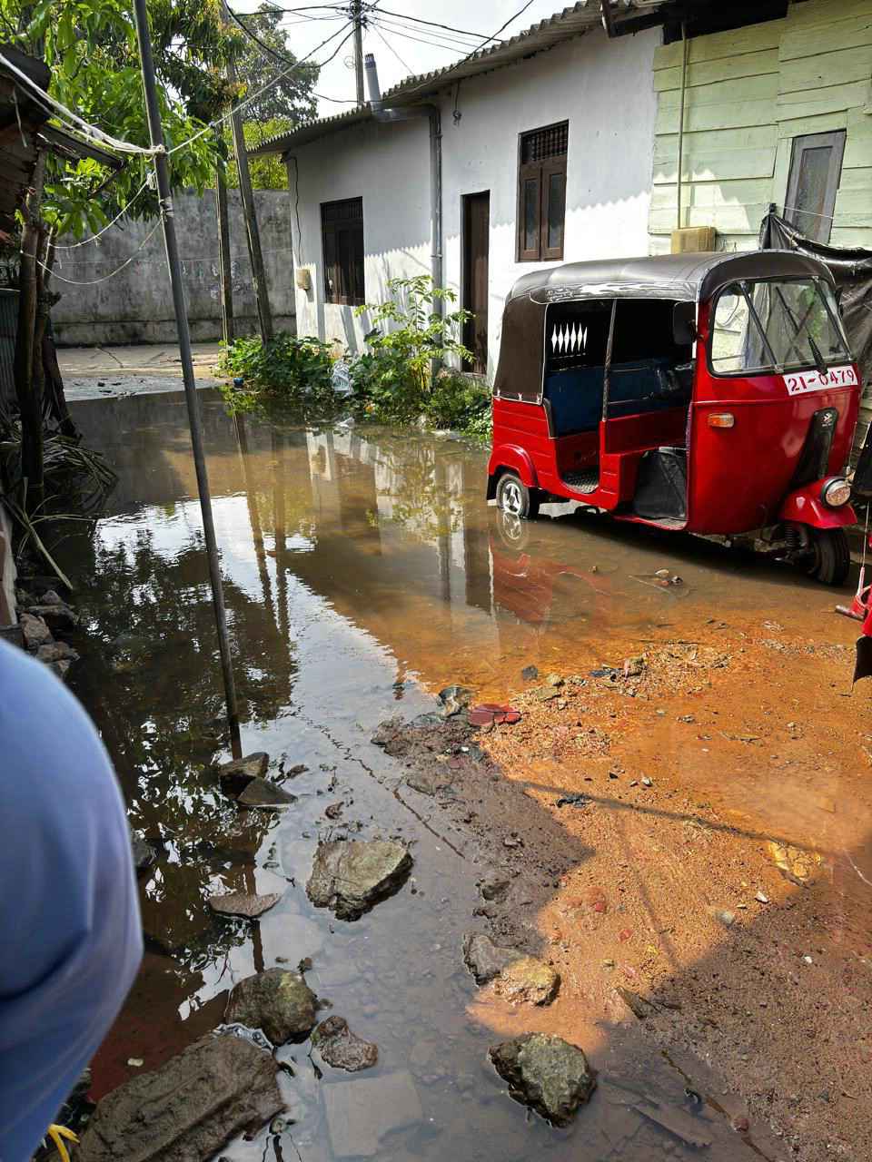 SriLanka_Ditwah_003_web Wasser steht in dem Weg zu einem Haus.