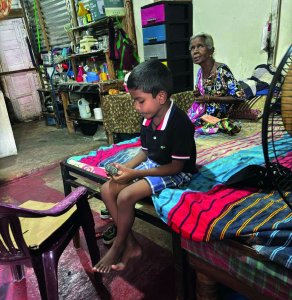 Ein Junge sitzt auf einem Bett.