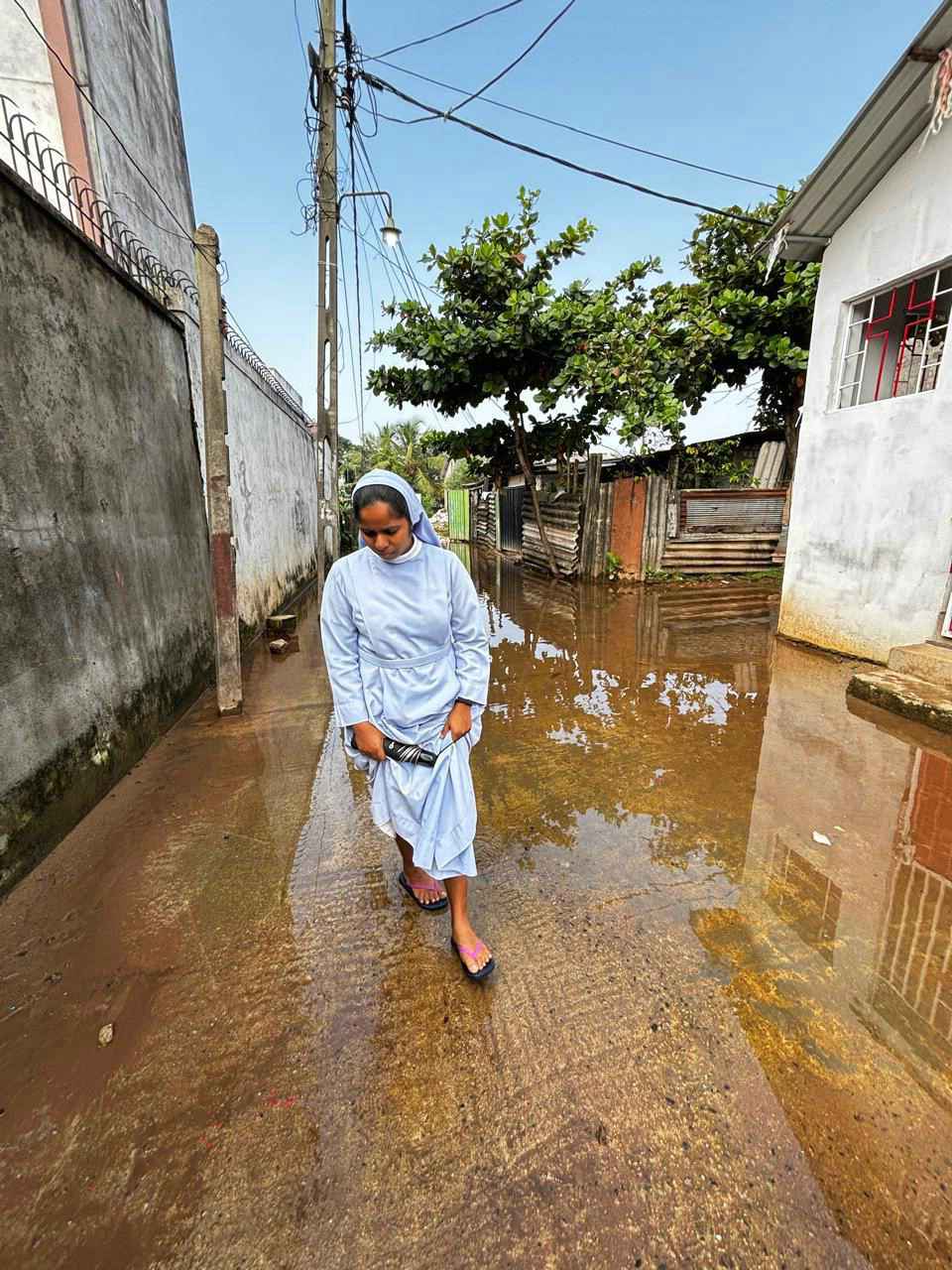 SriLanka_Ditwah_022_web Schwester in Sri Lanka watet durch das Wasser in der Straße